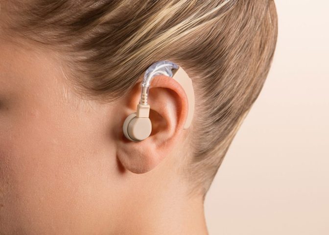 Người dùng đang đeo máy trợ thính sau tai, thể hiện sự tiện lợi và kín đáo của thiết bị trợ thính cá nhân