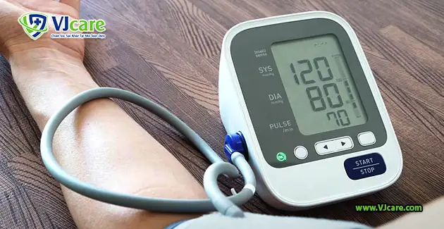 Người phụ nữ đang đo huyết áp tại nhà, đặt câu hỏi về chỉ số huyết áp 120/80 có bình thường không