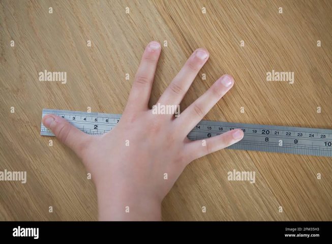 Đo kích thước bàn tay trẻ em 18 cm bằng thước kim loại